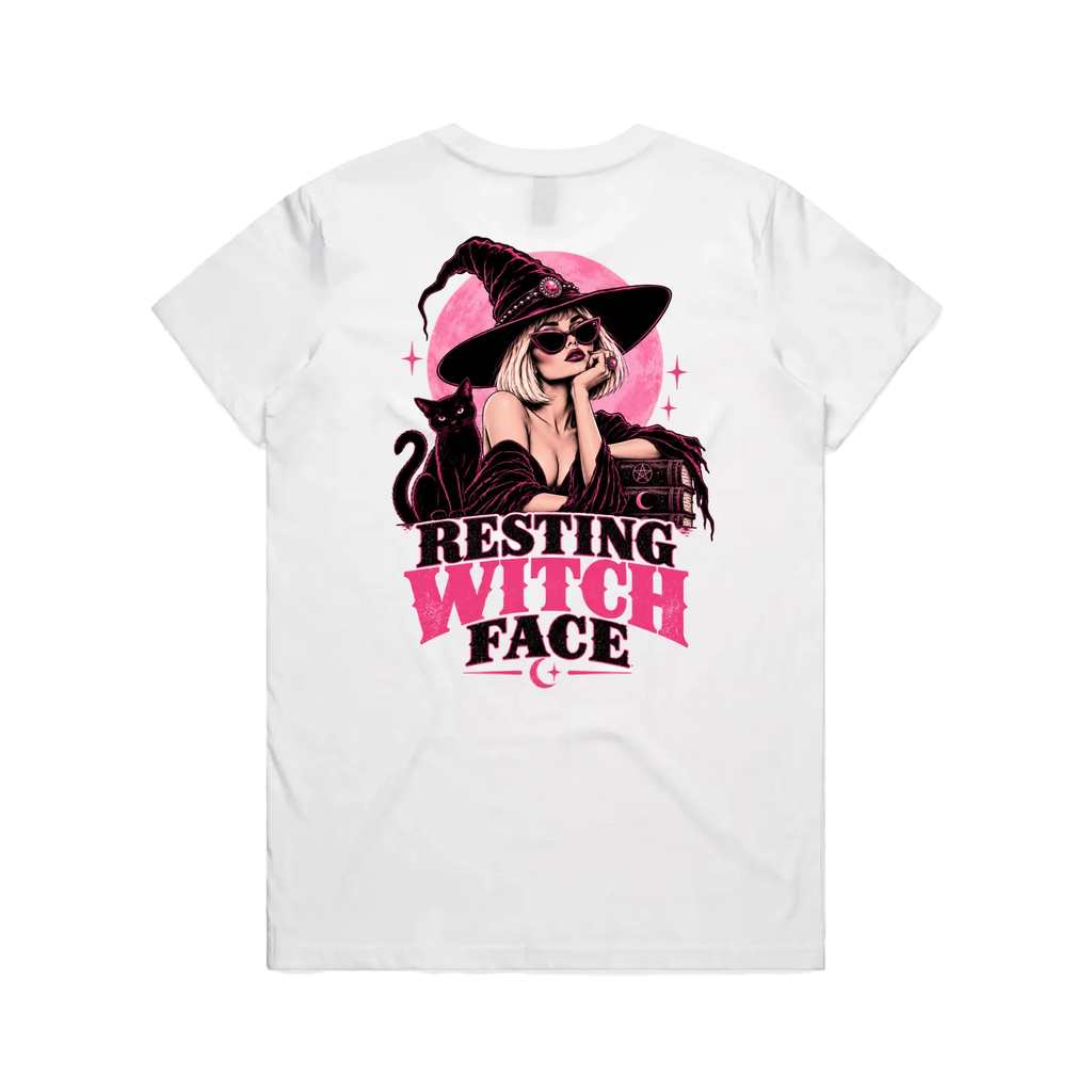 A white short-sleeve t-shirt shown from the back, featuring a graphic print of a woman in a witch hat with the text 'RESTING WITCH FACE' in pink and black.